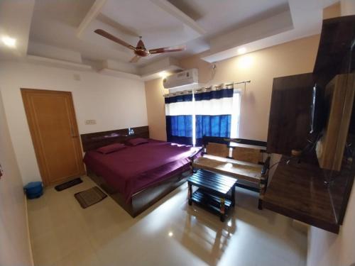 a bedroom with a bed and a ceiling fan at Home stay world in Bolpur