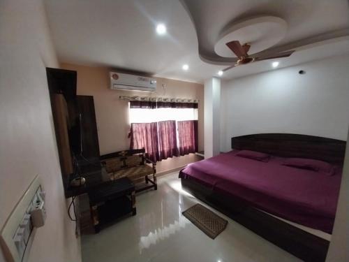 a bedroom with a purple bed and a window at Home stay world in Bolpur