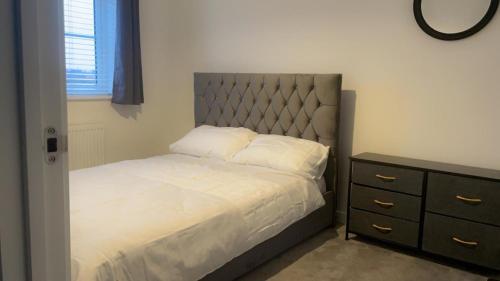 a bedroom with a bed and a dresser in it at Impeccable 3-Bed House in Northampton in Northampton