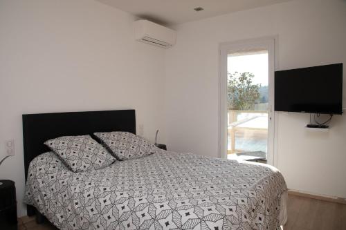 une chambre avec un lit et une télévision à écran plat dans l'établissement Maison avec piscine à Biot Antibes, à Biot