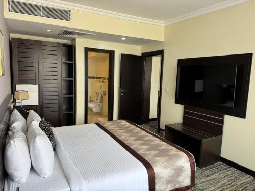 a bedroom with a bed and a flat screen tv at Golden Tulip Ibadan in Ibadan