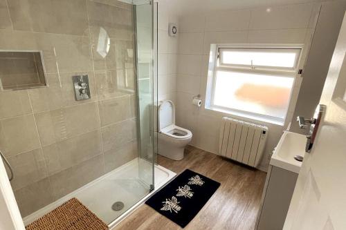 La petite salle de bains est pourvue d'une douche et de toilettes. dans l'établissement Spacious 3 bedroom house in heart of Hampton Court, à East Molesey