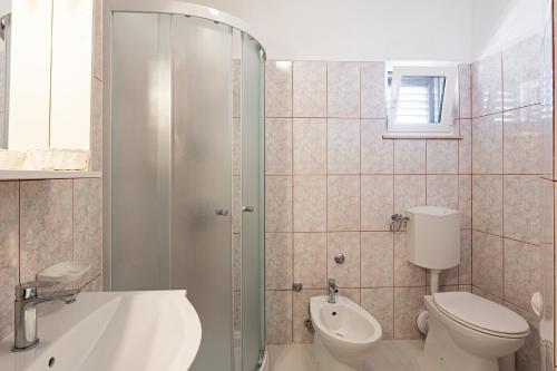 a bathroom with a toilet and a sink and a shower at Villa Amigo in Podstrana