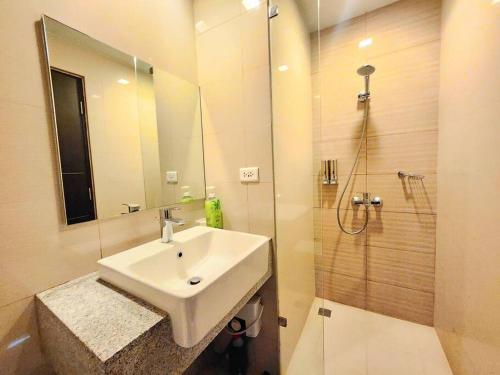 La salle de bains est pourvue d'un lavabo et d'une douche. dans l'établissement BGC Cosy Spacious 1BR Uptown Parksuites with Balcony City View, à Manille