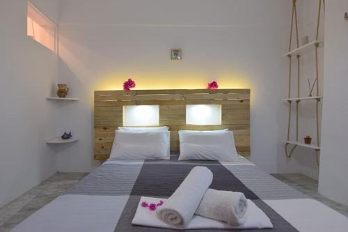 1 dormitorio con 1 cama con 2 toallas en Villa Nidito Santorini, en Vlychada Beach
