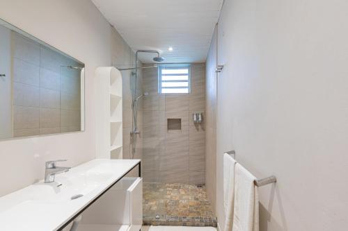 a white bathroom with a shower and a sink at Kisana Residence - Lovely 2 Bedroom Apartment - Pointe aux Canonniers in Pointe aux Cannoniers