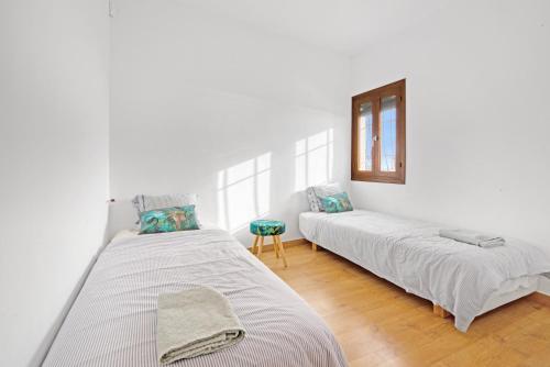 a white room with two beds and a window at Ca Xotxim in Altea