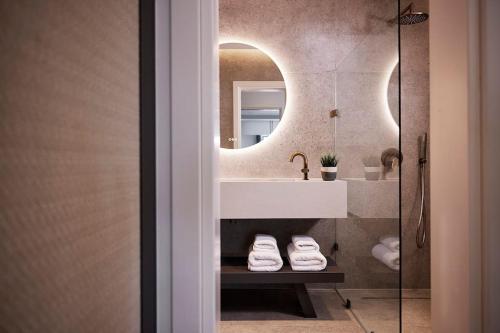 a bathroom with a sink and a mirror at Acropolis Grand Suite in Athens