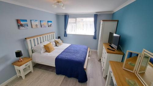 Dormitorio pequeño con cama y TV en Willow, en Saint Mawes