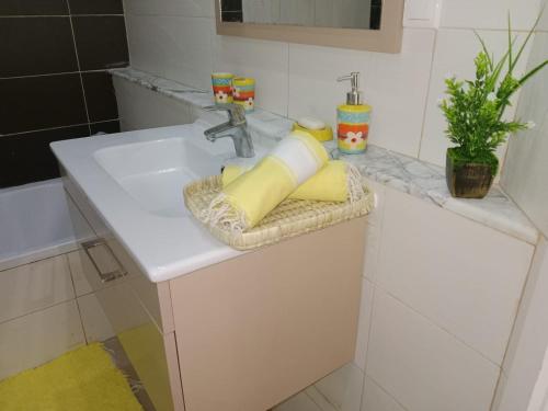 um lavatório de casa de banho com duas almofadas amarelas em Le cocon de Mariem à El Kantaoui em Port El Kantaoui
