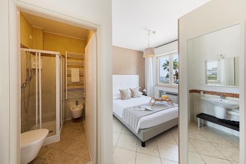 a bedroom with a bed and a bathroom with a sink at Residenza Miralago II by Wonderful Italy in Desenzano del Garda