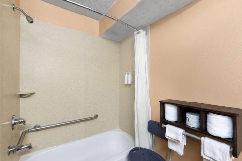 a bathroom with a bath tub and a toilet at Super 8 by Wyndham Myrtle Beach/Market Common Area in Myrtle Beach