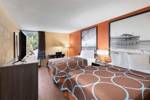 a hotel room with two beds and a television at Super 8 by Wyndham Myrtle Beach/Market Common Area in Myrtle Beach