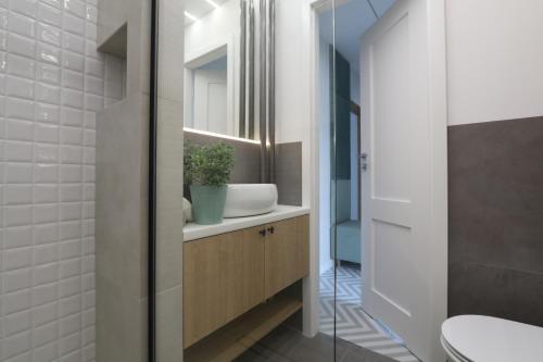 a bathroom with a sink and a toilet at Słodowiec Residence II in Warsaw