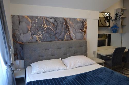 Un dormitorio con una cama con una pared de piedra encima. en Apartman "INSOMNIA" en Slavonski Brod