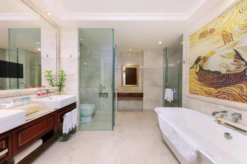 a bathroom with two sinks and a tub and a shower at WYNDHAM Foshan shunde in Shunde
