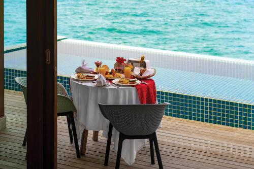 a table with food and drinks on a cruise ship at Atmosphere Kanifushi - Premium All Inclusive with Free Transfers in Lhaviyani Atoll