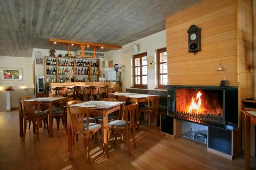 a bar with tables and a fireplace in a restaurant at Kerasies Guesthouse in Vovousa