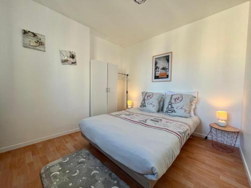 a small bedroom with a bed with two lamps at Rue de la paix 3 personnes - 10'min Paris in Les Lilas