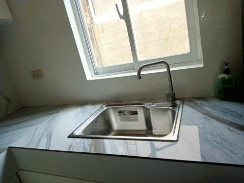 a sink in a kitchen with a window at CASITA DE ZACATE in Cagayan de Oro