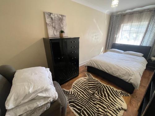 a small bedroom with a bed and a dresser at the woodland apartment 1 in London