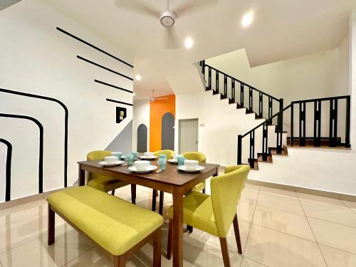 a dining room with a wooden table and yellow chairs at Ipoh IGB Homestay by Comfort Home in Ipoh