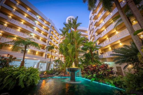 un patio del hotel con una fuente frente a un edificio en DoubleTree by Hilton Cairns en Cairns