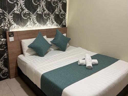 a bed with a pair of shoes sitting on it at KUANTAN BESERAH BUDGET HOTEL in Kuantan