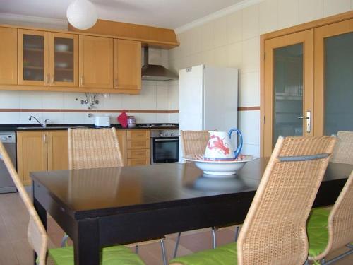 uma cozinha com uma mesa com cadeiras e um frigorífico em Fantastic 3 bedroom Villa - Peniche - Mer&Surf em Atouguia da Baleia