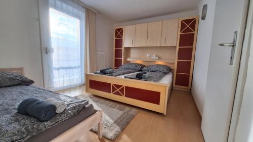 a bedroom with two beds and a large window at Holiday Apartment 2 Villach in Villach