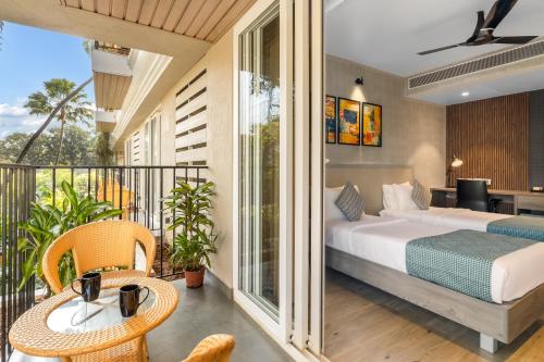 1 dormitorio con 1 cama y balcón en Quality Inn Ocean Palms Goa, en Calangute