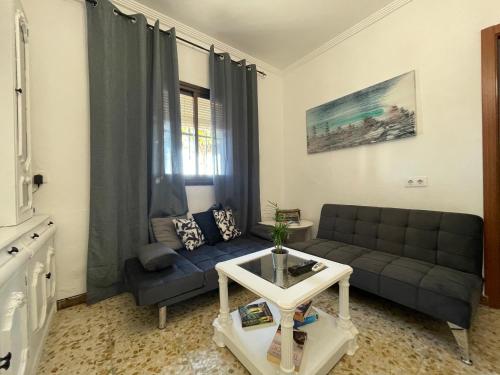 ein Wohnzimmer mit einem Sofa und einem Tisch in der Unterkunft Casa LuLa in Villafranca de Córdoba