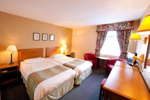 Cette chambre comprend deux lits et un bureau. dans l'établissement Ox Hotel Carlisle, à Carlisle