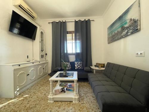 a living room with a couch and a tv at Casa LuLa in Villafranca de Córdoba