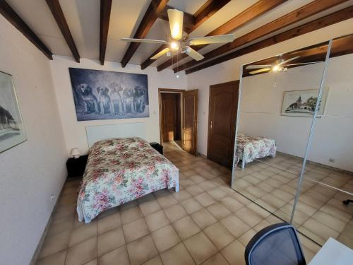 - une chambre avec un lit et un ventilateur de plafond dans l'établissement Leuke authentieke vakantiewoning voor 6 personen, à Oedelem