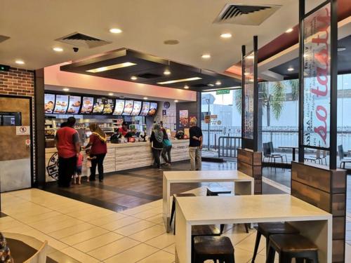 people in a fast food restaurant with tables and people at Ipoh IGB Homestay by Comfort Home in Ipoh