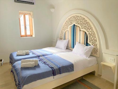 a bedroom with two beds with towels on them at Hôtel Djerba Authentique - Au centre de Midoun in Midoun