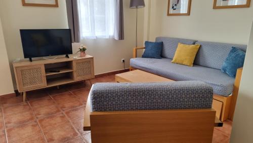 Una sala de estar con un sofá y un televisor. en Apartamento Altura T2, en Altura