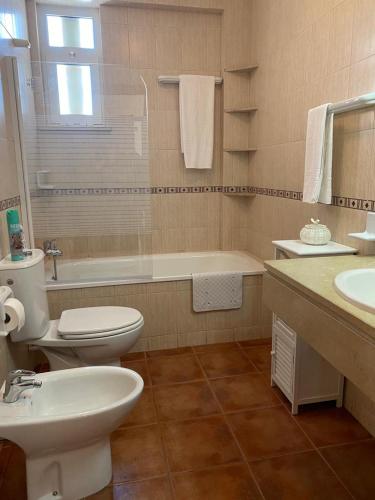 a bathroom with a toilet and a sink and a tub at Apartamento Altura T2 in Altura
