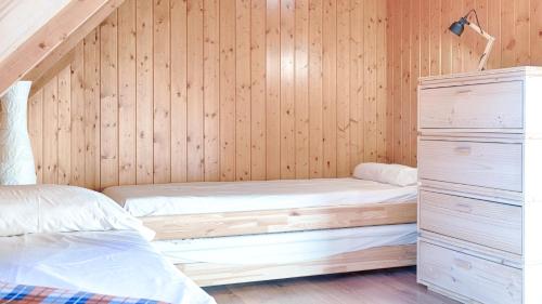 two beds in a room with wooden walls at Saplan Real Estate DUPLEX LONGUERA in Les