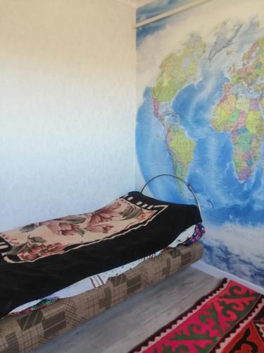 ein Schlafzimmer mit einer Weltkarte an der Wand in der Unterkunft Гостевой дом (Hostel) in Kochkorka