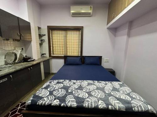 バンガロールにあるAmazing AC Studio in E City 1F 102のベッドルーム1室(青と白の掛け布団付きのベッド1台付)