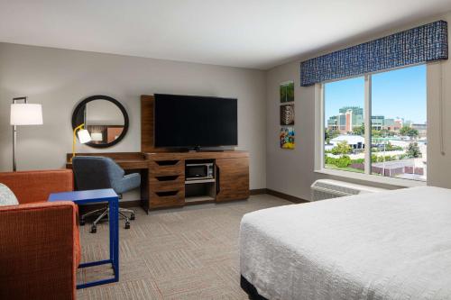 a hotel room with a bed and a flat screen tv at Hampton Inn Green Bay Stadium, Wi in Green Bay