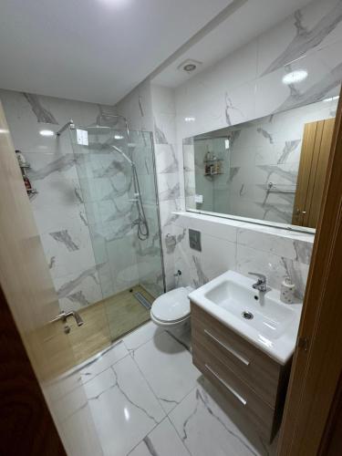 y baño con ducha, aseo y lavamanos. en Luxury AÏDA FLAT, en Tánger