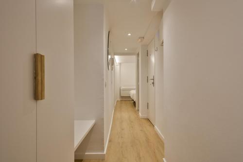 a hallway with white walls and wooden floors at Ola Living Vidreria in Barcelona