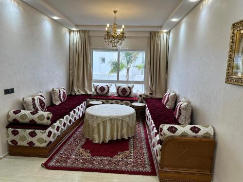 a living room with a couch and chairs and a window at Luxury AÏDA FLAT in Tangier