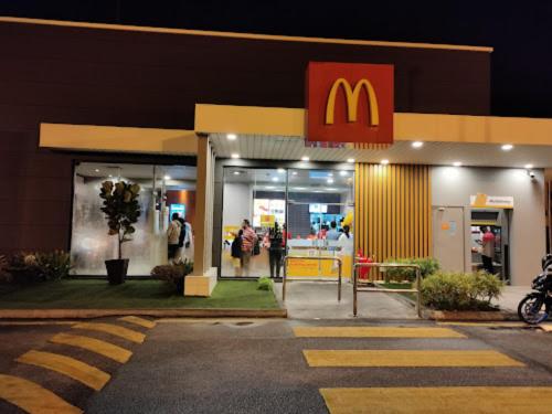 a mcdonalds restaurant with people walking into it at night at Ipoh IGB Homestay by Comfort Home in Ipoh