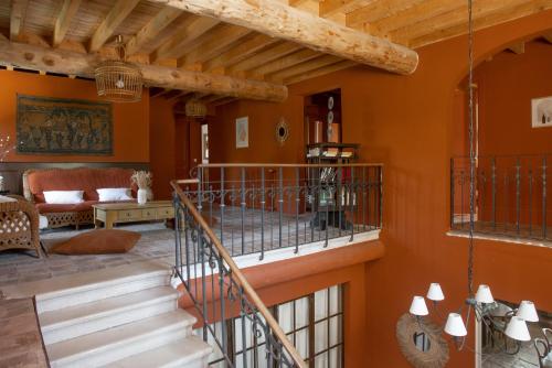 a living room with orange walls and stairs at Domaine de Barbe - Chambre Lin in Salles-sous-Bois