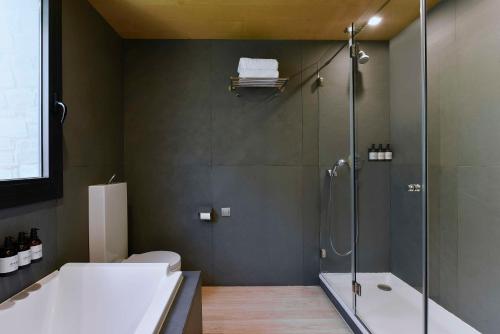 a bathroom with a shower and a toilet and a tub at NH Collection Andorra Palomé in La Massana