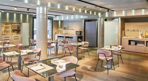 a restaurant with tables and chairs in a room at NH Collection Andorra Palomé in La Massana